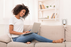 Woman using a laptop on her couch at home