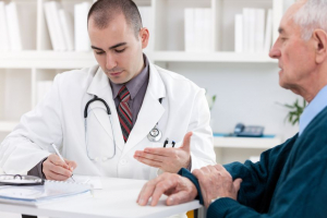 Portrait of handsome male doctor talking with senior patient