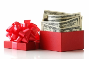 Bundle of one hundred dollar bills in a gift box with a red bow